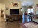 Open concept living area with a large TV, hardwood floors, and seamless flow to adjacent rooms at 1002 Plummer Rd, Martinsville, IN 46151