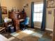 Well-lit home office with a vintage roll-top desk, comfortable chair, and ample natural light at 1002 Plummer Rd, Martinsville, IN 46151