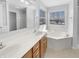 Well-lit bathroom featuring double sinks, a large mirror, and a luxurious soaking tub at 1059 Sugar Maple Dr, Greenwood, IN 46143