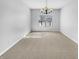 Carpeted dining room with a chandelier, large window looking out to a snowy scene at 1059 Sugar Maple Dr, Greenwood, IN 46143