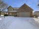 Charming two-story home with brick facade, attached garage, and snow-covered front yard on a sunny day at 1059 Sugar Maple Dr, Greenwood, IN 46143