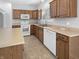 Spacious kitchen featuring oak cabinets, white appliances, and tile flooring at 1059 Sugar Maple Dr, Greenwood, IN 46143