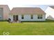 Backyard featuring a well-maintained lawn, patio with grill, and a sliding glass door to the home at 11026 Cool Winds Way, Fishers, IN 46037