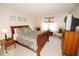 Cozy bedroom featuring a sleigh bed, soft carpet, and comforting natural light streaming through the window at 11026 Cool Winds Way, Fishers, IN 46037