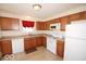 Well-lit kitchen with wood cabinets, white appliances, laminate countertops, and a tile floor for a clean design at 11026 Cool Winds Way, Fishers, IN 46037