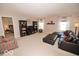 Spacious living room with neutral carpeting, dark wood furnishings, a large sectional sofa, and natural light from windows at 11026 Cool Winds Way, Fishers, IN 46037