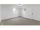 A bright bedroom features neutral carpet, white walls, and two windows with natural light at 1159 S Bradley Ave, Indianapolis, IN 46203
