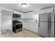 Modern kitchen with stainless steel appliances, white cabinetry, and light wood-look floors at 1159 S Bradley Ave, Indianapolis, IN 46203