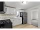 Updated kitchen with stainless steel appliances, white cabinets, light counter tops and wood-look floors at 1159 S Bradley Ave, Indianapolis, IN 46203