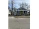 A cozy home with a bright yellow door, inviting front porch, and detached garage at 1237 E 29Th St, Anderson, IN 46016