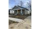 Charming home featuring a welcoming front porch, yellow door, and freshly mulched yard at 1237 E 29Th St, Anderson, IN 46016
