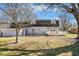 View of the home's backyard with a deck and mature trees at 1310 Bowman Dr, Greenfield, IN 46140