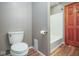 The bathroom features a white toilet and shower with a wood door nearby at 1310 Bowman Dr, Greenfield, IN 46140