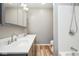 Updated bathroom with a double vanity, laminate floors, and a shower with white tile at 1310 Bowman Dr, Greenfield, IN 46140
