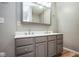 Updated bathroom features double vanity with ample lighting, sleek gray cabinets, and laminate flooring at 1310 Bowman Dr, Greenfield, IN 46140