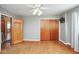 Bright bedroom featuring wood floors, ceiling fan, and double closet with wood doors at 1310 Bowman Dr, Greenfield, IN 46140
