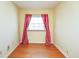 Sunny bedroom with hardwood floors and a window with red and white striped curtains at 1310 Bowman Dr, Greenfield, IN 46140