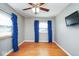 Bright bedroom features hardwood floors, a ceiling fan, and a window with blue curtains at 1310 Bowman Dr, Greenfield, IN 46140