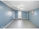 Empty bonus room with blue walls, painted floors, and a door leading to the outside at 1310 Bowman Dr, Greenfield, IN 46140