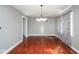 Bright dining room with hardwood floors, modern chandelier, and colorful patterned curtains at 1310 Bowman Dr, Greenfield, IN 46140