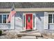 Close-up of the red front door with a glass insert, flanked by sconces and an American flag at 1310 Bowman Dr, Greenfield, IN 46140