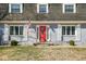 Charming home with a red front door, grey brick, shutters, and a well-maintained lawn at 1310 Bowman Dr, Greenfield, IN 46140