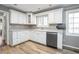 Well-lit kitchen featuring white cabinetry, stainless steel dishwasher, and lots of counter space at 1310 Bowman Dr, Greenfield, IN 46140