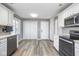 Bright kitchen featuring white cabinets, stainless steel appliances, and wood grain flooring at 1310 Bowman Dr, Greenfield, IN 46140