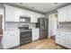 Kitchen featuring white cabinets, stainless steel appliances, and wood grain flooring at 1310 Bowman Dr, Greenfield, IN 46140