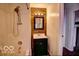 Compact bathroom features a dark vanity and a shower with wood-look paneling at 1334 Hannibal St, Noblesville, IN 46060