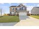 Charming two-story home featuring a stone and blue siding exterior and an attached two car garage at 13615 Moorcroft Dr, Fishers, IN 46037
