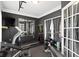 A well-equipped home gym including weights, mirrors, and french doors at 13615 Moorcroft Dr, Fishers, IN 46037