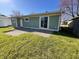Backyard featuring a sliding glass door, gravel patio, and a lush, green lawn at 1378 South St, Noblesville, IN 46060