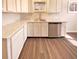 A modern kitchen with white cabinets, marble countertops, stainless steel appliances, and wood-look flooring at 1378 South St, Noblesville, IN 46060