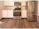 Well-lit kitchen with white cabinetry, stainless steel appliances, and wood-look flooring at 1378 South St, Noblesville, IN 46060