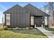 Modern home featuring dark vertical siding, a concrete walkway, and a well-manicured lawn at 1510 Columbia Ave, Indianapolis, IN 46202