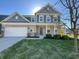Charming two-story home with a combination brick and blue siding, attached garage, and well-manicured lawn at 15704 Millwood Dr, Noblesville, IN 46060