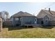 This home's backyard has a grey deck with outdoor seating, a well-kept lawn, and a privacy fence at 1718 Gilmore St, Columbus, IN 47201