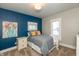 Cozy bedroom with a striking blue accent wall and natural light at 1718 Gilmore St, Columbus, IN 47201