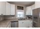 Bright kitchen features stainless steel appliances, ample counter space, and white cabinets at 1718 Gilmore St, Columbus, IN 47201