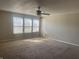This bedroom with neutral walls features natural light, plush carpet, and a ceiling fan at 1735 Sonesta Ln, Indianapolis, IN 46217