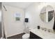 Cozy bathroom features modern sink and vanity, round mirror, and a tiled shower at 1953 N Linwood Ave, Indianapolis, IN 46218