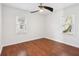 A bright bedroom with hardwood floors, two windows, and ceiling fan at 1953 N Linwood Ave, Indianapolis, IN 46218