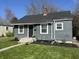 Well-maintained gray home with a dark roof, tidy landscaping, and an inviting front entrance at 1953 N Linwood Ave, Indianapolis, IN 46218