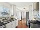 Well-lit kitchen featuring white cabinets, stainless steel appliances, and dark countertops, connecting to the living area for easy entertaining at 1953 N Linwood Ave, Indianapolis, IN 46218