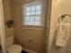 A close-up of a bathroom features a window, toilet, towel rack and white door at 2341 California St, Columbus, IN 47201