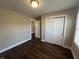 A clean bedroom features neutral walls, wood flooring, a large window, and a closet with double doors at 2341 California St, Columbus, IN 47201