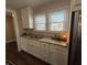 A modern kitchen features white cabinets, granite countertops, a stainless steel sink, and a bright window at 2341 California St, Columbus, IN 47201