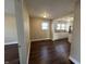 A bright living room featuring hardwood floors leads into the kitchen with white cabinetry and ample counter space at 2341 California St, Columbus, IN 47201