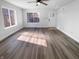 Bright living room featuring modern hardwood floors, a ceiling fan, and a large window for natural light at 2365 Grand Fir Dr, Greenwood, IN 46143